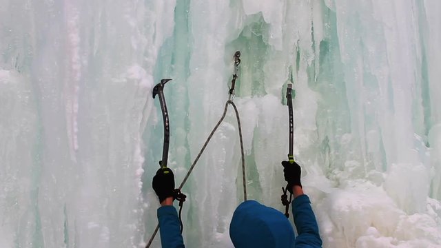 NOVOSIBIRSK, RUSSIA - December  04, 2016: Young man with ice axes and crampons training to climb on icefall