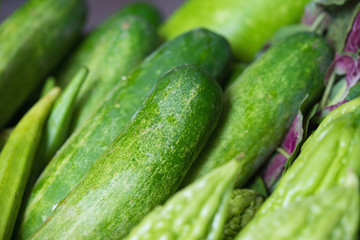 Tropical green organic vegetable on basket on wooden background