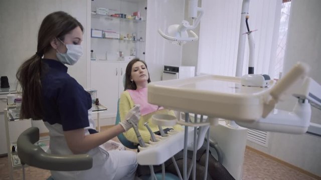 Dentist makes procedures and treat teeth for a beautiful patient woman in dental clinic. Concept of healthy life