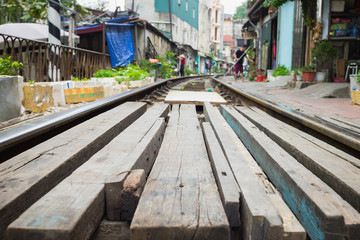 Fototapeta na wymiar Wooden path crossing railway rail in Vietnam. Concept of unsafe railway
