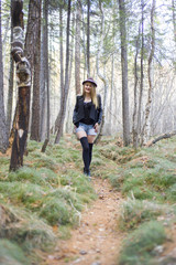 Naklejka na ściany i meble Beautiful young girl walking in the autumn forest.