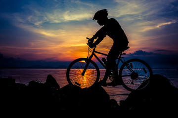 Healthy lifestyle. Silhouette of bicyclist riding the bike at seaside