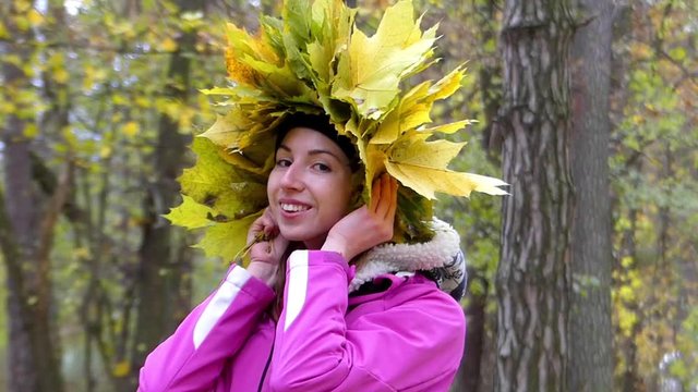 Girl With Smile on Her Face Dresses Wreath of Yellow Leaves.