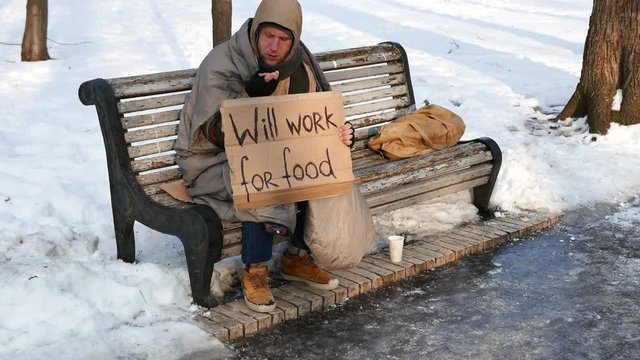 
4K.Young  unemployment   man on bench in  winter city park. No job is problem
