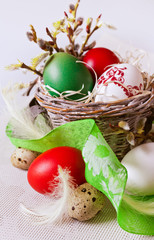 Traditional Czech easter decoration - my handmade painted eggs with quail egg and feather in the wicker basket. Spring easter holiday arrangement.