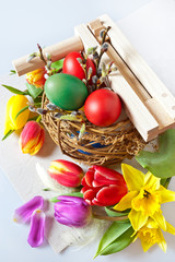 Traditional Czech easter decoration - my handmade painted red and green eggs with tulip flowers and regional music instrument ratchet. Spring easter holiday arrangement.