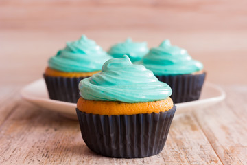 Mint cupcakes on the wooden background. Close-up.