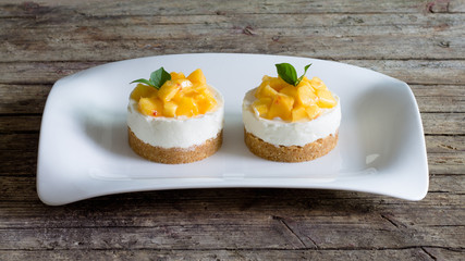 Cheesecake with peaches on wooden background