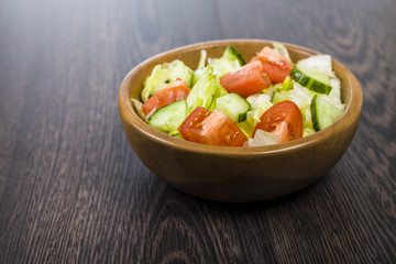 Salad in wooden bowl on a table close-up. Concept of healthy nut