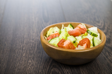 Salad in wooden bowl on a table close-up. Concept of healthy nut