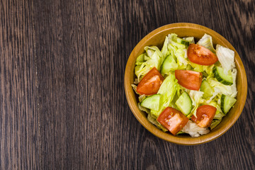 Salad in wooden bowl on a table close-up. Concept of healthy nut