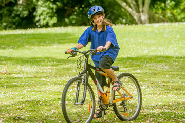 Obraz premium young happy preteen child boy riding a bicycle on natural park b