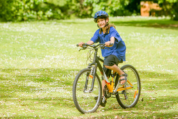Fototapeta premium young happy preteen child boy riding a bicycle on natural park b
