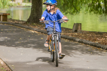 Fototapeta premium young happy preteen child boy riding a bicycle on natural park b