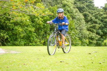 Obraz premium young happy preteen child boy riding a bicycle on natural park b
