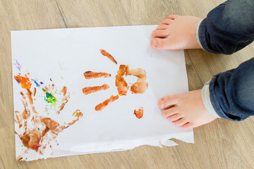 handprints of cute child drawing at home