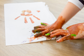 handprints of cute child drawing at home