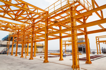 Yellow steel construction in open at factory.