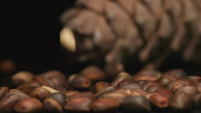 SLOW MOTION: Peeled pine nuts fall on a table