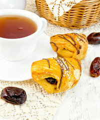 Cookies with dates and tea in cup on board