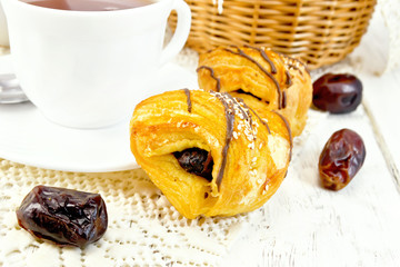 Cookies with dates and tea in white cup on board