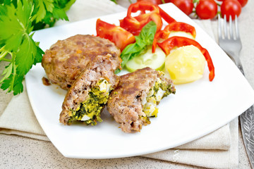 Cutlets stuffed in plate on stone table