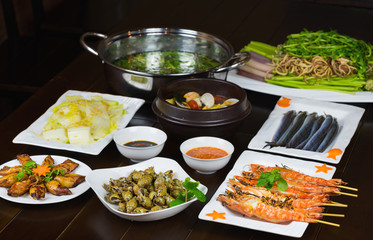Set of Vietnamese seafood with Barbecue tiger shrimps, grilled squid, stir fried cabbage, spicy steam clam and fish hot pot with vegetable