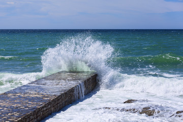 big sea wave splashing against pier in Novigrad. Croatia.