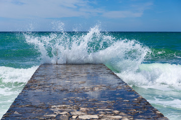 big sea wave splashing against pier in Novigrad. Croatia.