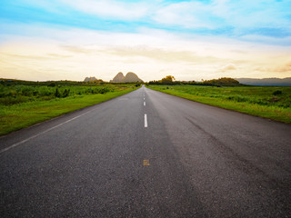 asphalt road with yellow blue sky background during sunset