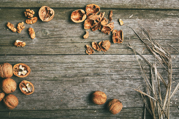 Walnuts on rustic wooden board background with straw copy space for text