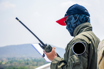 the soldier is using a military radio.