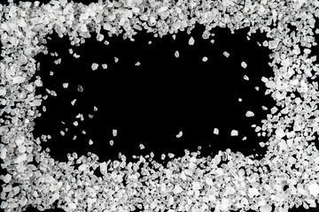 Sea salt grains frame on the black background.