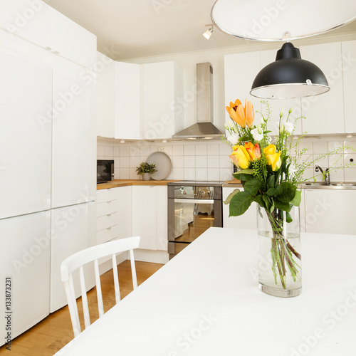 "detail of a fancy kitchen, vase with flowers at the kitchen table