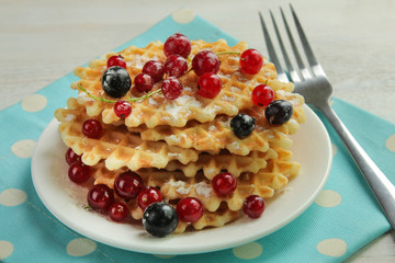Baked waffles with fresh berries on the plate. Breakfast.