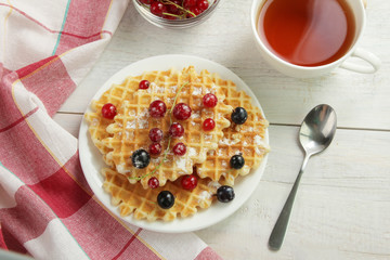 Baked waffles with fresh berries on the plate. Breakfast.