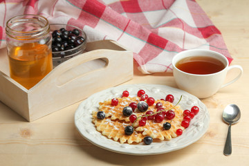 Baked waffles with fresh berries on the plate. Breakfast.
