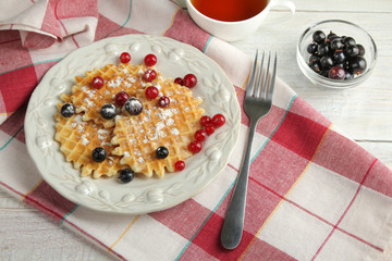 Baked waffles with fresh berries on the plate. Breakfast.