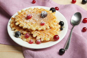 Baked waffles with fresh berries on the plate. Breakfast.