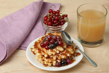 Baked waffles with fresh berries on the plate. Breakfast.