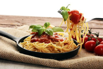 Plate of delicious spaghetti Bolognaise or Bolognese with savory minced beef and tomato sauce garnished with parmesan cheese and basil