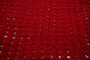 Red cardigan knitted in manual photographed in close-up.