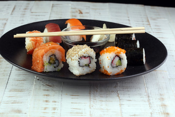 close up of sashimi sushi set with chopsticks and soy - sushi roll with salmon and sushi roll with...