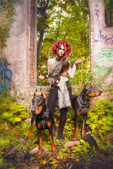 Girl Amazon with Dobermans in the ruins of an old house