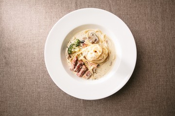 steak cream pasta on table