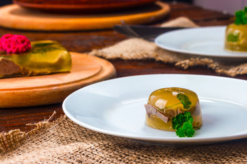 dish jellied tongue with horseradish in red on a white plate