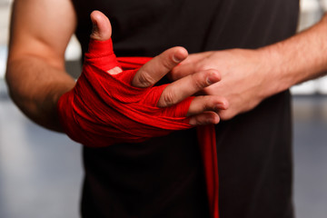 Athlete wears red boxing bandages