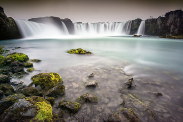 Godafoss, Iceland - Looking up at huge waterfall with rocks in t