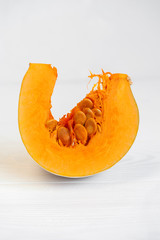 Piece of orange pumpkin on the white wooden table