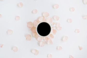 Coffee cup and pink roses petals pattern. Flat lay, top view
